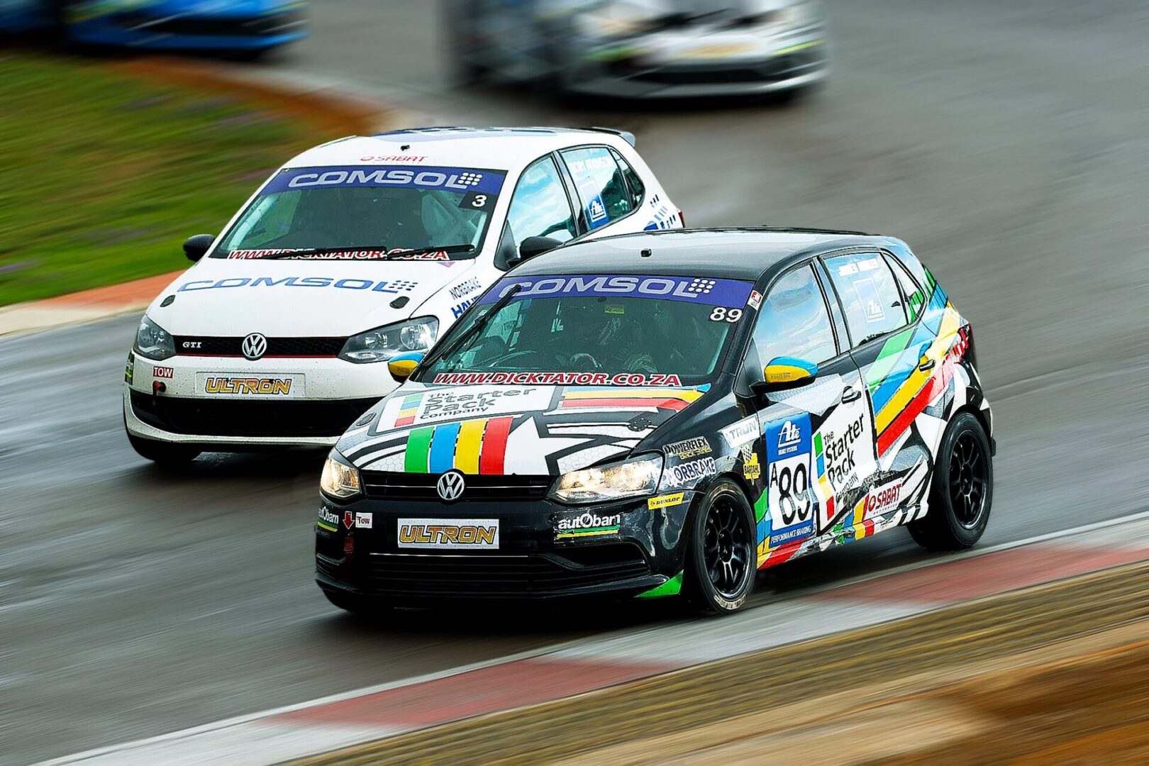 Two race cars on a wet track.