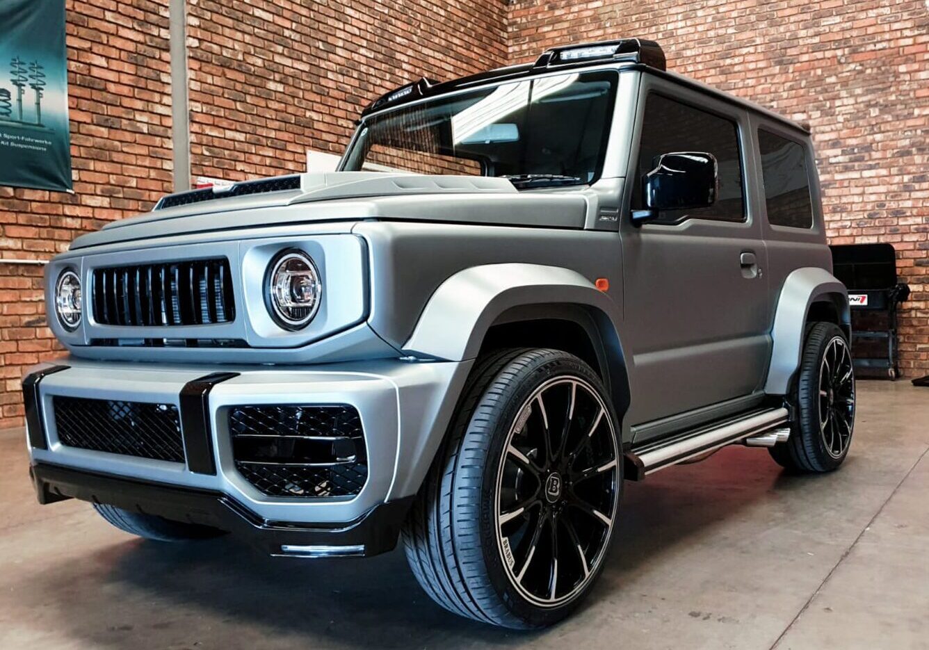 Matte gray SUV with black rims indoors.