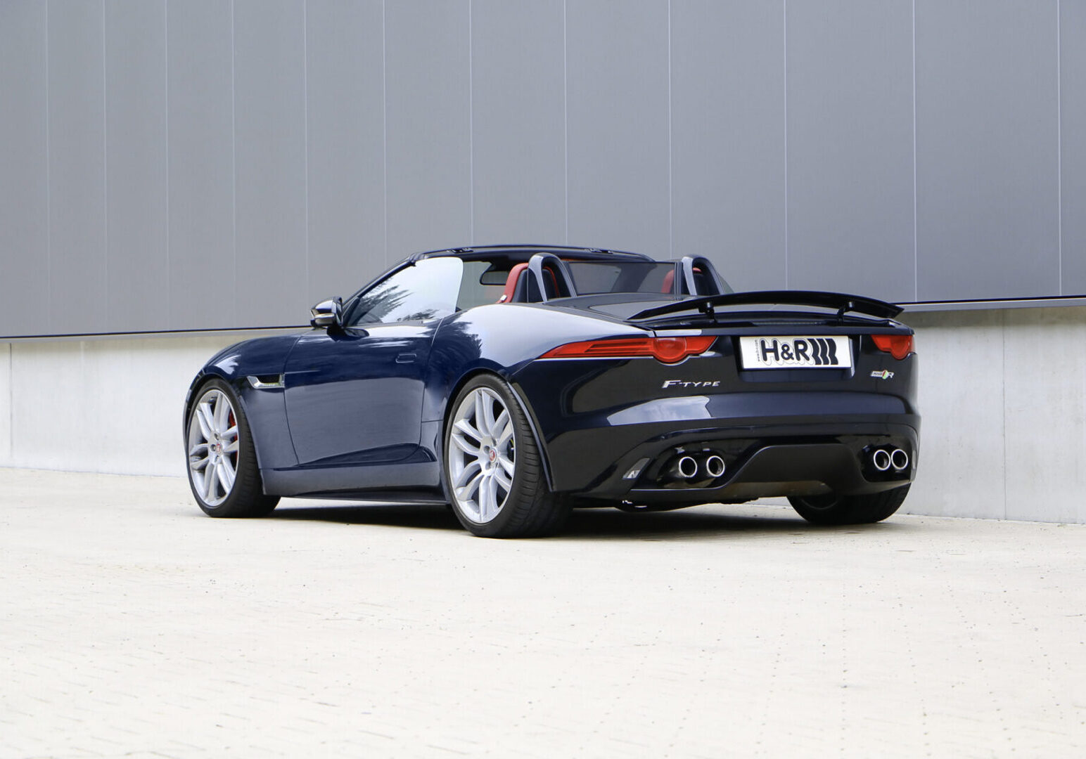 Convertible sports car parked near a wall.