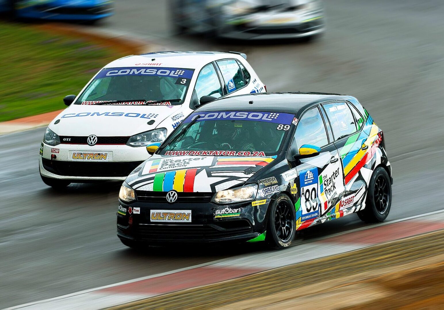 Two racing cars competing on wet track.